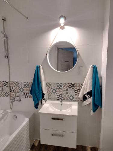 uma casa de banho com um lavatório, um espelho e uma banheira em Apartament Rumia Trójmiasto Kaszuby em Rumia