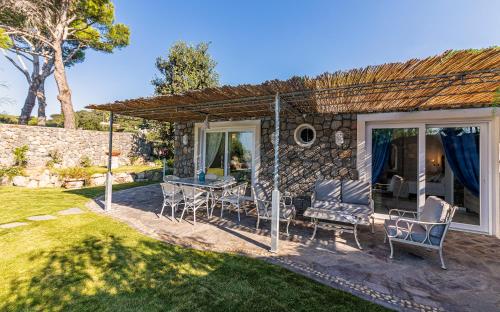a patio with a table and chairs in a yard at Villa dei Lecci - 7 Luxury villas with private pool or jacuzzi in Ischia