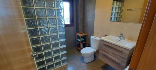 a bathroom with a toilet and a sink and a mirror at La Cabra Trepadora in Neril