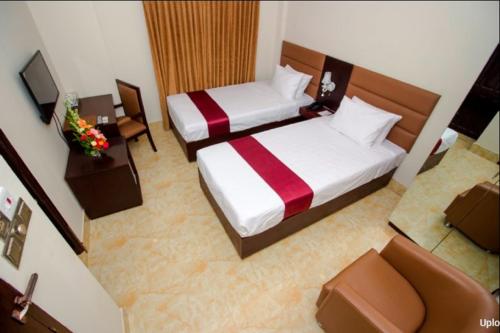 um quarto com duas camas e uma televisão e um quarto em Hotel Gulshan Lake View em Dhaka
