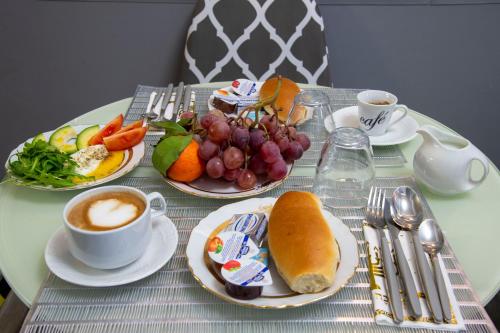 a table with plates of food and a cup of coffee at Lea Luxury Rooms in Rome