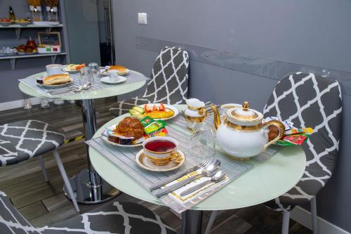 a table with plates of food and tea on it at Lea Luxury Rooms in Rome