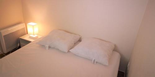 - 2 oreillers dans un lit dans l'établissement Résidence Cap Azur Appartement 209, à Villeneuve-Loubet