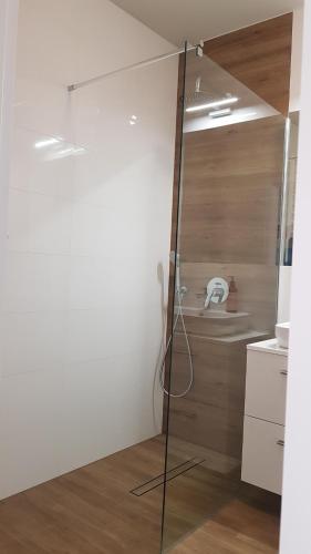 a glass shower in a kitchen with a wooden floor at Nowoczesny apartament przy Aquapark Reda in Reda