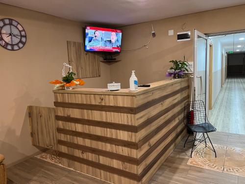 a bar in a room with a tv on the wall at Hotel Tatul in Momchilgrad