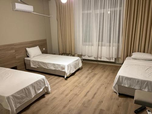 a hotel room with two beds and a window at Hotel Tatul in Momchilgrad