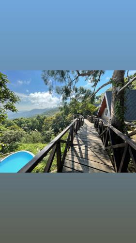 a wooden bridge with a tree and a house at La View Mountain Resort in Damasanan