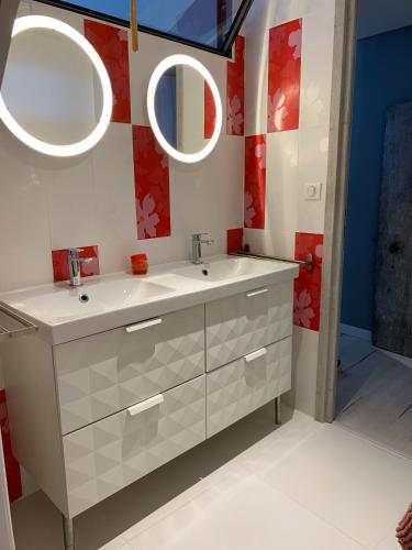 une salle de bain avec un lavabo et deux miroirs dans l'établissement Clos du Cardinal, à LʼIsle-sur-la-Sorgue