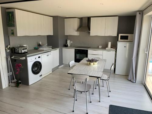 a kitchen with a table and chairs in a room at Clos du Cardinal in L'Isle-sur-la-Sorgue