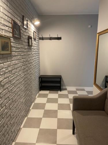 a living room with a couch and a brick wall at Apartamenty Komorniki in Komorniki