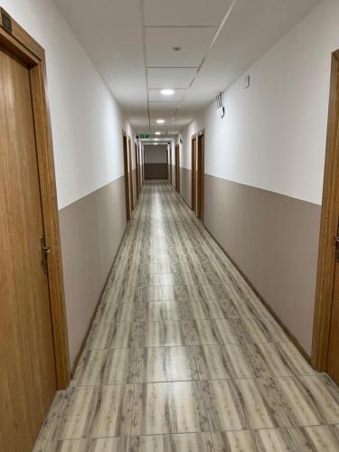 an empty hallway in an office building with a wooden floor at Hotel Tatul in Momchilgrad