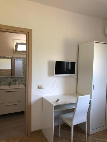 a white desk with a chair and a tv on a wall at Casa Giulia in Niscemi