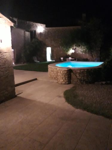 a backyard at night with a swimming pool at La Migrane in Villevieille