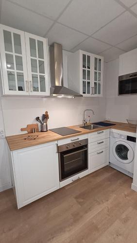 une cuisine avec des armoires blanches, un évier et un lave-vaisselle dans l'établissement Studio Neuf climatisé Centre ville #5, à Toulon