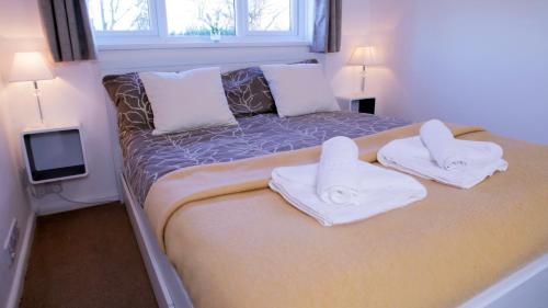 a bedroom with a bed with towels on it at FREE parking, Central Location,1 Bedroom Apartment near Tattersalls in Newmarket