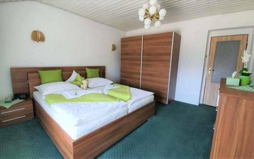a bedroom with a large bed with green pillows at Retrohaus in Liptovský Mikuláš