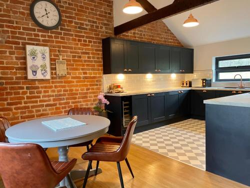 uma cozinha com uma mesa e uma parede de tijolos em Hayes Suite em Oswestry