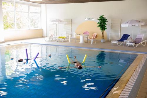 un groupe de personnes nageant dans une piscine dans l'établissement App 613 Panoramic Hohegeiß Terrassenhaus, à Hohegeiss