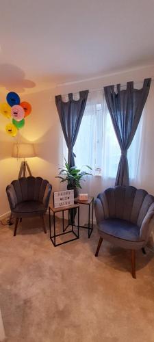 two chairs and a table in a living room at Sunny-side-up in St Austell