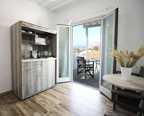 eine Küche und ein Esszimmer mit einem Tisch und einem Balkon in der Unterkunft Crystal View Mykonos in Mykonos Stadt