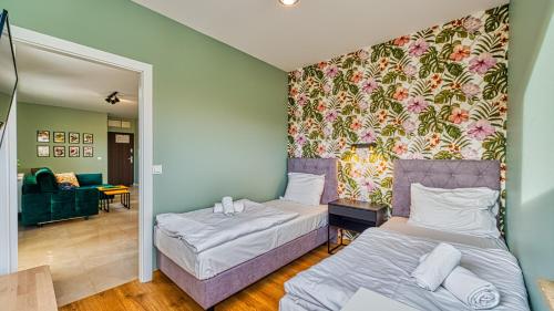 希维拉杜夫-兹德鲁伊Apartament Kwiatowy - 5D Apartamenty的一间带两张床的卧室和一间客厅