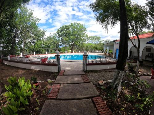 a swimming pool in a yard with a fence at Hotel Matamundo in Neiva