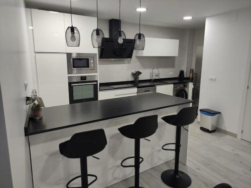 eine Küche mit einer Theke mit vier Stühlen in der Unterkunft El Rincón de Moreno in Munébrega