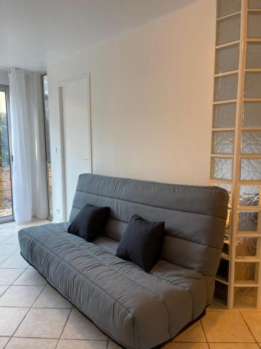 ein Ledersofa in einem Wohnzimmer mit Bücherregal in der Unterkunft Appartement avec piscine proche bord de mer in Cagnes-sur-Mer