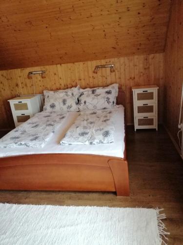 um quarto com uma cama e duas mesas de cabeceira em GOLDENVENDÉGHÁZ em Balatonszabadi