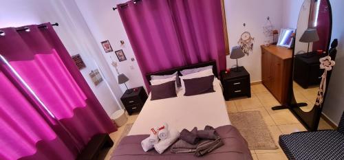 a bedroom with purple curtains and a bed with a couch at Charalambous Apartment in Paphos