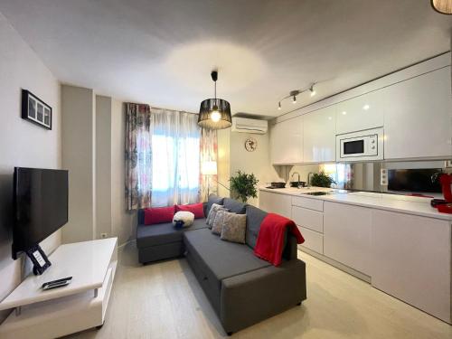 ein Wohnzimmer mit einem Sofa und einer Küche in der Unterkunft Neverending Loft in Málaga