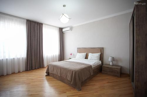 a bedroom with a bed with white walls and wood floors at Zurabashvili Guest House in Sighnaghi