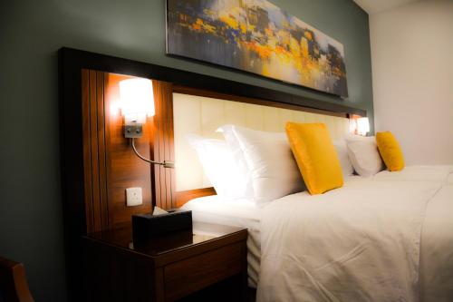 ein Hotelzimmer mit einem Bett und einem Bild an der Wand in der Unterkunft Park Town in Dschidda