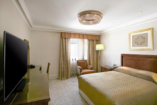 a hotel room with a bed and a flat screen tv at The Oberoi Madina المدينة أوبروي in Al Madinah