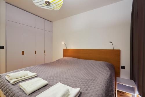 une chambre avec un lit avec deux serviettes dessus dans l'établissement RV Apartment Onyx, à Starý Smokovec