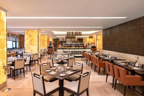 a restaurant with tables and chairs and a bar at The Oberoi Madina المدينة أوبروي in Al Madinah