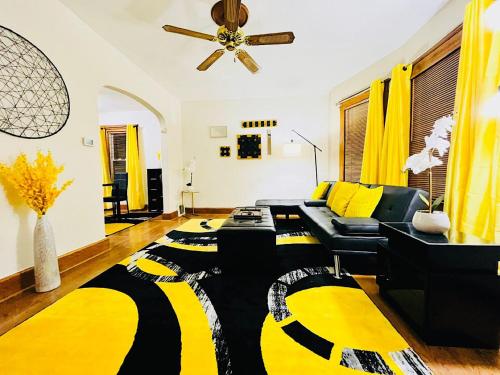 a living room with a black and yellow rug at The Amber Retreat - Brooklyn Centre Comfort - Charming Space for Families, Couples & Business Travelers Near Downtown - With 300MB WiFi, Parking & Self Check-In in Cleveland