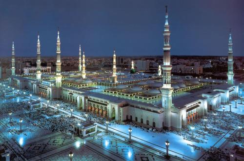 a large mosque with a lot of people in it at night at The Oberoi Madina المدينة أوبروي in Al Madinah