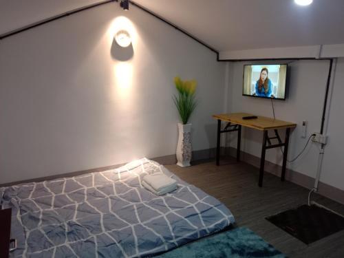 a bedroom with a bed and a tv on a wall at Lavendrata I in Phnom Penh