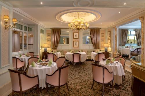 a dining room with tables and chairs and a chandelier at The Oberoi Madina المدينة أوبروي in Al Madinah