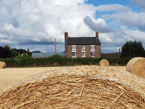 a large pile of hay in front of a house at Upper Eyton Farmhouse B&B in Shrewsbury