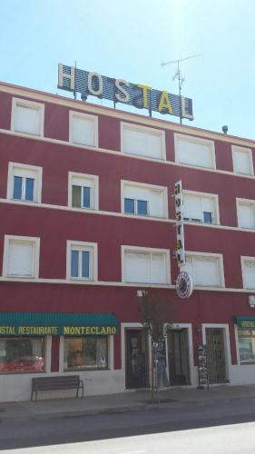 a red building with a sign on top of it at Hostal Monteclaro in Ponferrada