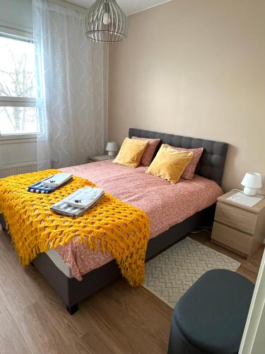 a bedroom with a bed with a yellow blanket at Cozy centre apartament Kuopio in Kuopio