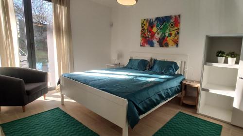 um quarto com uma cama com lençóis azuis e uma cadeira em Porto Arrábida Gaia, Big comfortable, 4or6 pax, ground floor em Vila Nova de Gaia