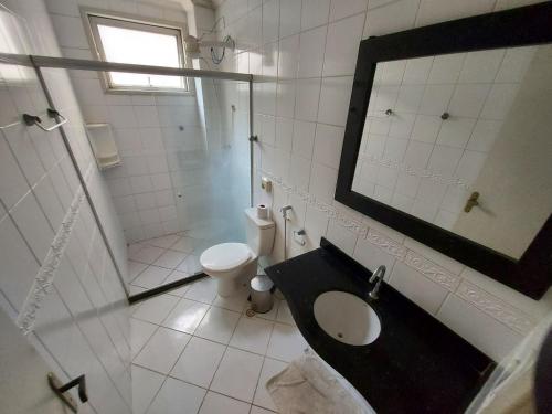 ein Bad mit einem Waschbecken, einem WC und einer Dusche in der Unterkunft Lindo apartamento 50 metros da praia do morro, três quartos e duas vagas de garagem in Guarapari