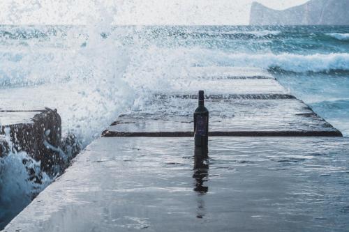 a bottle of wine sitting on a pier in the ocean at Funtana'e Mari in Gonnesa