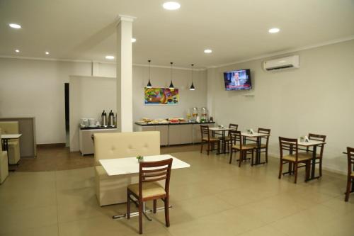 a restaurant with tables and chairs and a counter at Prata Hotel in Santarém