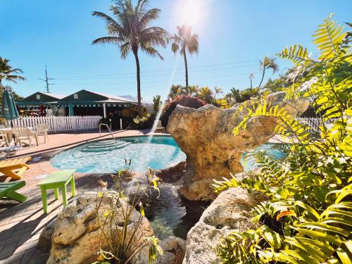 a swimming pool with a waterfall in a garden at The Ocean View Inn in Islamorada