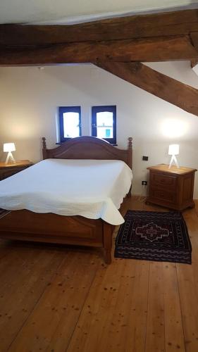 a bedroom with a large bed and two windows at GITE AU PETIT RUISSEAU-Etage et combles-maison alsacienne 4 personnes 4 nuitées minimum in Langensoultzbach