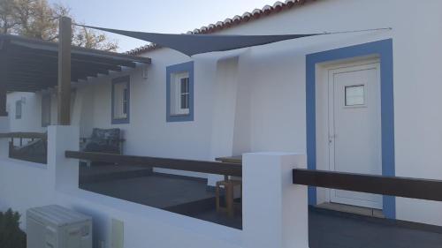 a white house with a door and a balcony at Herdade de Vale Maceiras in Santiago do Cacém